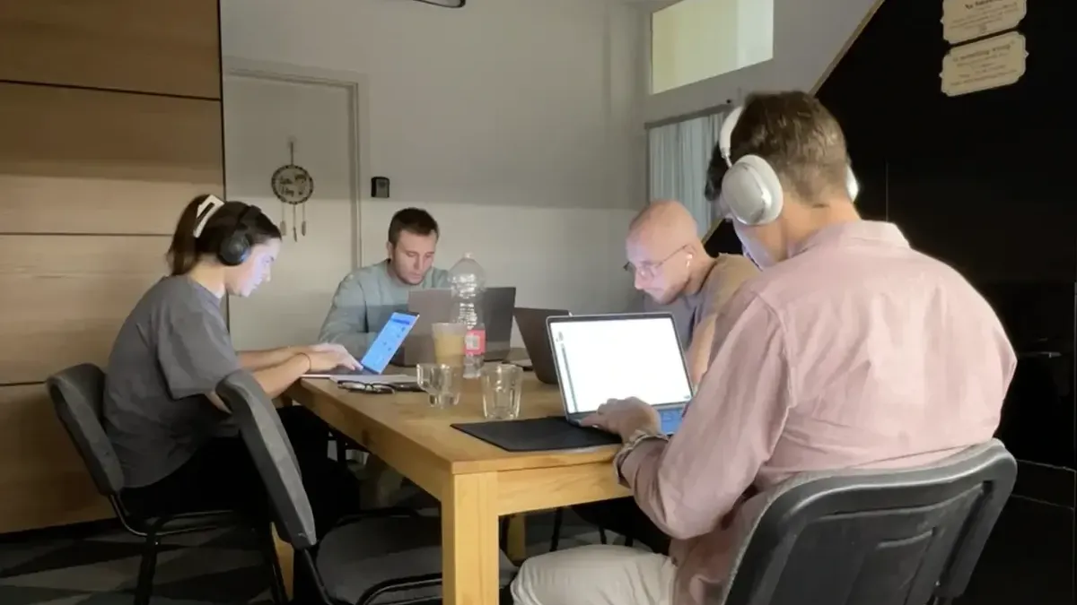 Group of entrepreneurs working together at a shared table in a coliving house