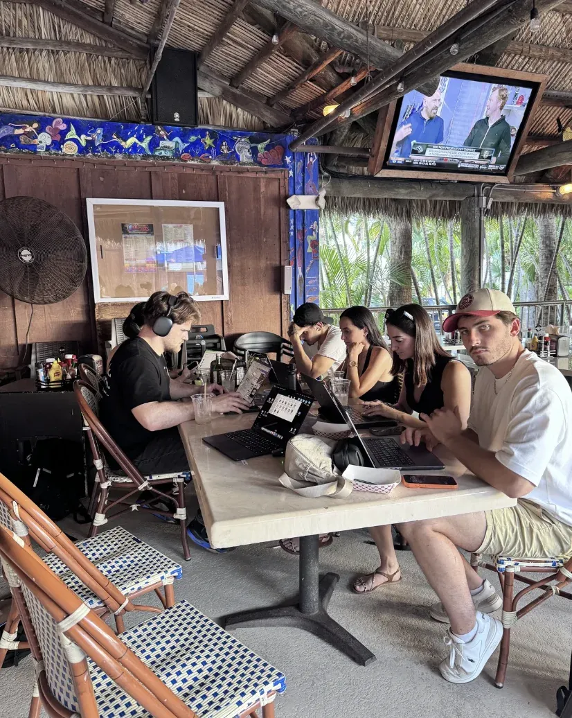 Group of entrepreneurs working on laptops at an outdoor bar in Miami